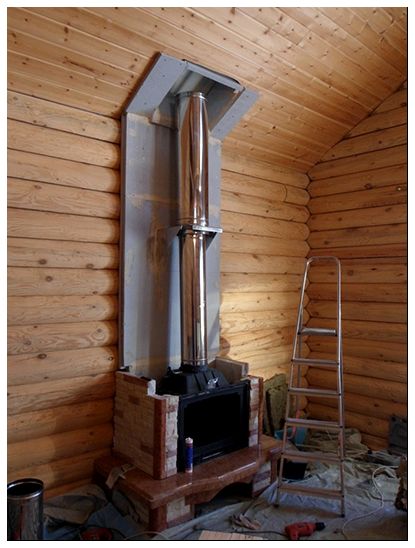 На фото - пример установки стальной трубы в деревянном коттедже